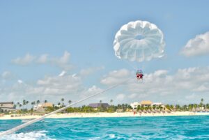 couple-parasailing-over-crystal-blue-water-in-domi-2022-11-02-18-16-50-utc